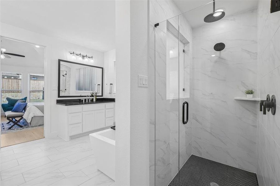 Full bath featuring a marble finish shower, a freestanding tub, light marble finish flooring, vanity, and ensuite bath Full bath featuring a marble finish shower, a freestanding tub, light marble finish flooring, vanity, and ensuite bath