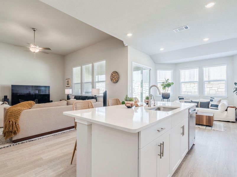 An open concept living area connects seamlessly with a modern kitchen, creating an inviting space for gatherings; functional seating area, dining, secondary living space.