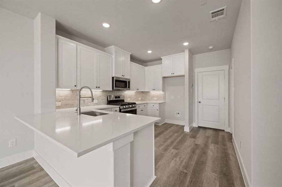 The kitchen peninsula offers a great place for a quick bite or homework station.