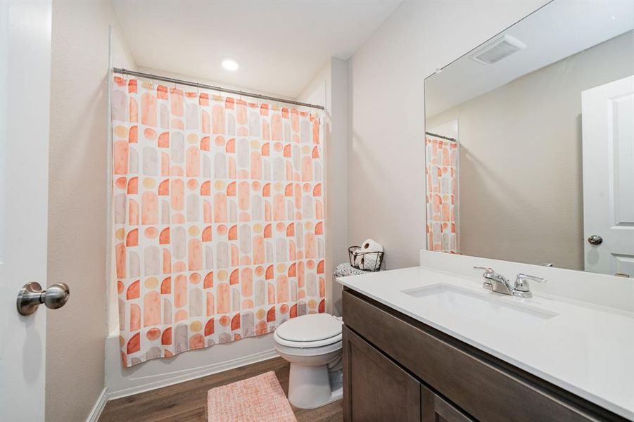 Bathroom featuring shower / bathtub combination with curtain, dark wood finished floors, vanity, and recessed lighting Bathroom featuring shower / bathtub combination with curtain, dark wood finished floors, vanity, and recessed lighting
