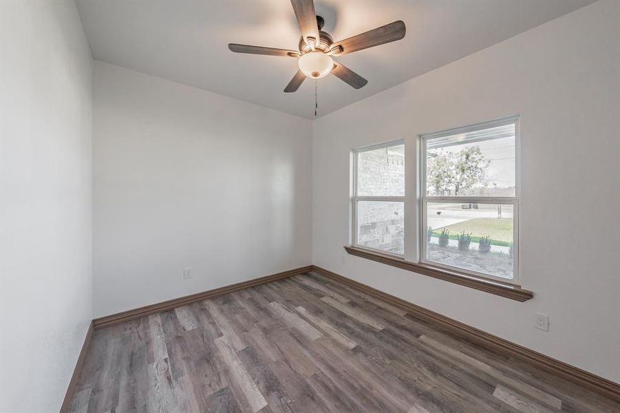 Empty room with ceiling fan, baseboards, and wood finished floors