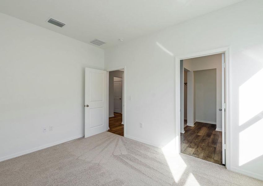 Master bedroom featuring a full bathroom with a walk-in closet.