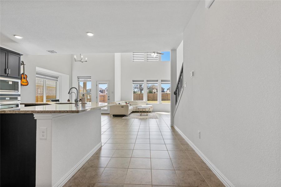 An open-concept living space integrates a kitchen island with a bright, naturally illuminated great room. An open-concept living space integrates a kitchen island with a bright, naturally illuminated great room.