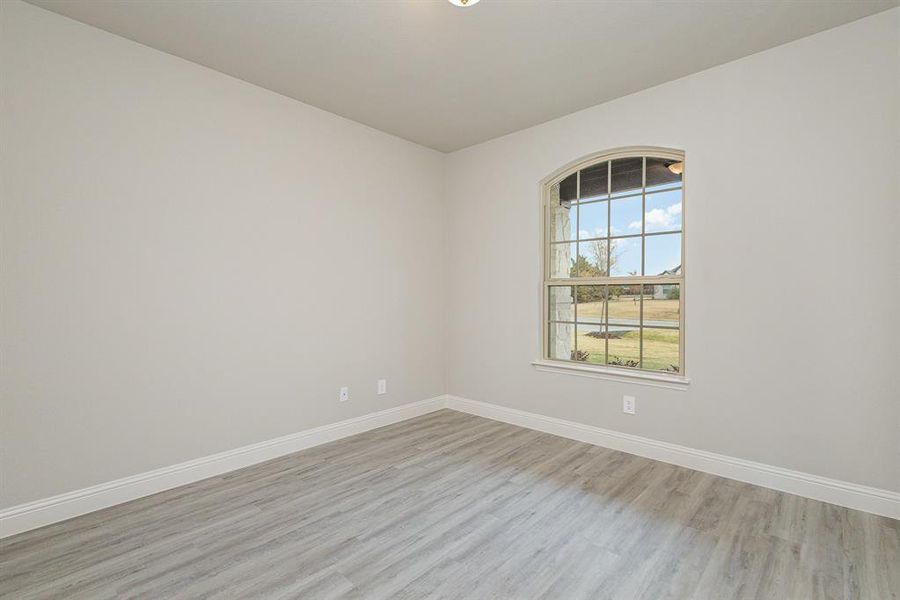 Empty room with light hardwood / wood-style flooring