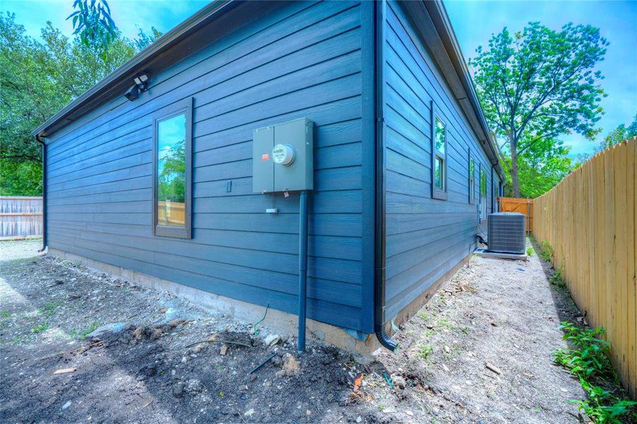 Exterior featuring horizontal lap siding in a deep blue tone, contrasting dark trim, and a concrete foundation
