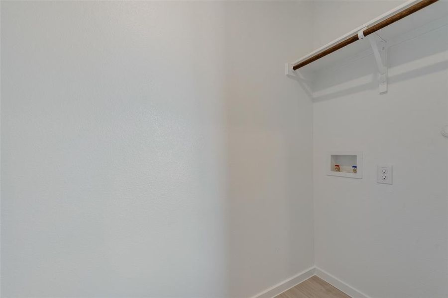 Laundry room with hardwood / wood-style flooring and washer hookup