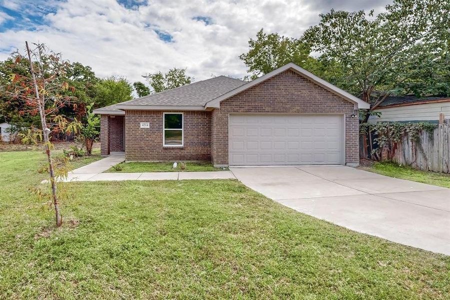 Ranch-style home featuring a front lawn and a garage