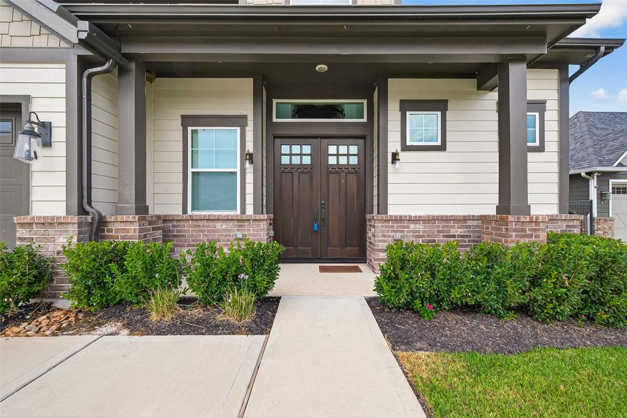 Inviting front entrance with double doors, brick detailing, and mature landscaping. Exceptional curb appeal just steps from scenic lake views. Inviting front entrance with double doors, brick detailing, and mature landscaping. Exceptional curb appeal just steps from scenic lake views.