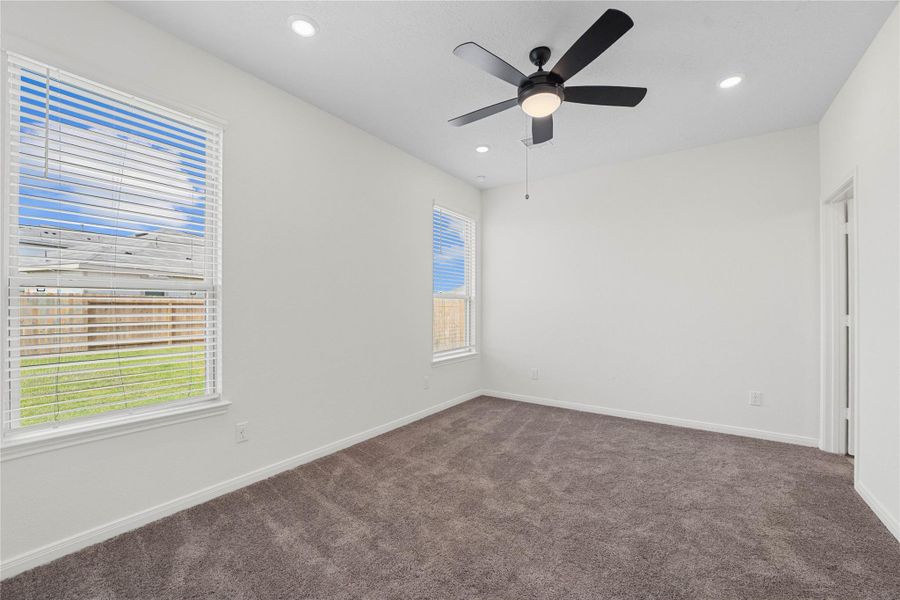 Come and unwind after a long day in this magnificent primary suite! This spacious room features plush carpet, neutral tone paint, high ceilings, ceiling fan with lighting, recessed lighting, and large windows with privacy blinds. Come and unwind after a long day in this magnificent primary suite! This spacious room features plush carpet, neutral tone paint, high ceilings, ceiling fan with lighting, recessed lighting, and large windows with privacy blinds.