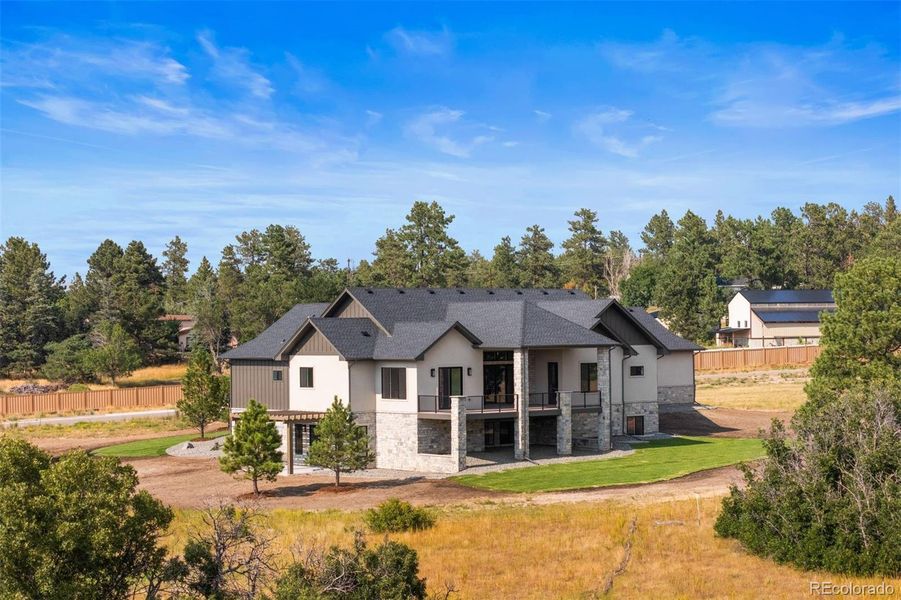 The home showcases fantastic outdoor living with a covered deck, front porch, and pergola-topped patio, all overlooking scenic views and community trails.