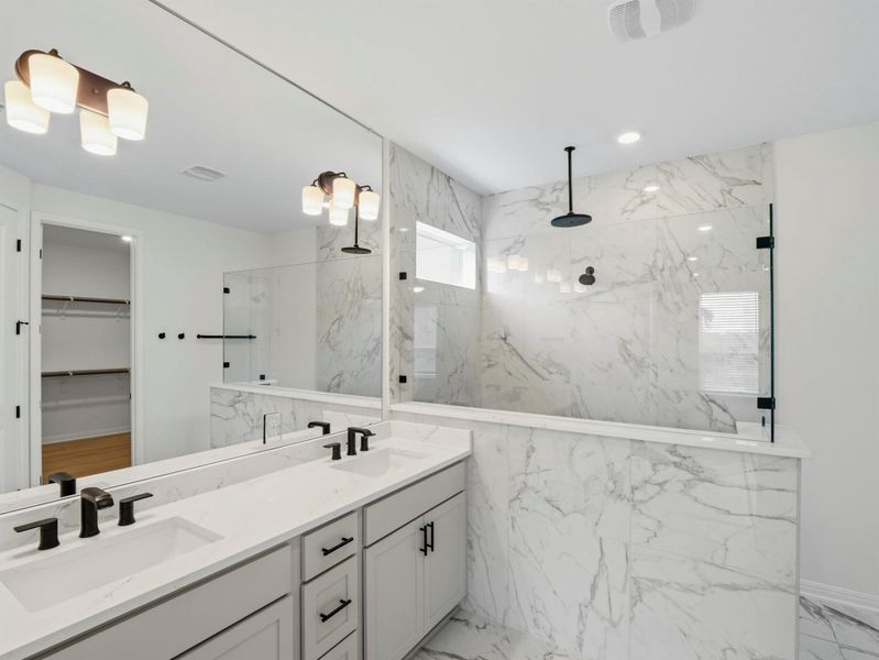 Marble-clad shower and double vanity create a serene and functional primary bathroom retreat. Marble-clad shower and double vanity create a serene and functional primary bathroom retreat.