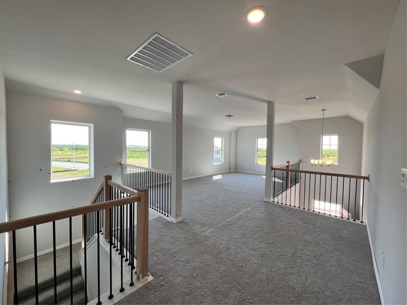 Corridor featuring an upstairs landing, carpet, and a chandelier