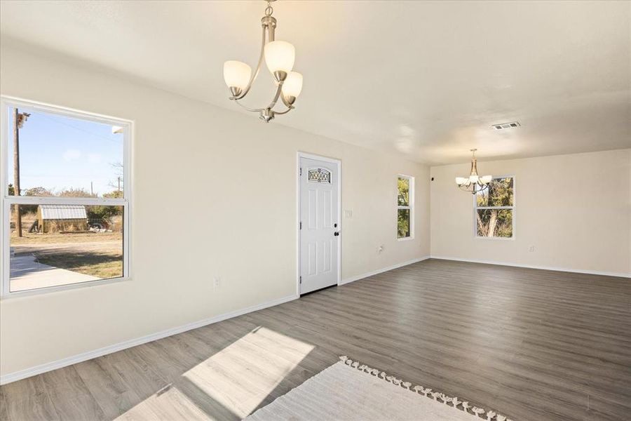 Unfurnished room featuring dark hardwood / wood-style floors and an inviting chandelier