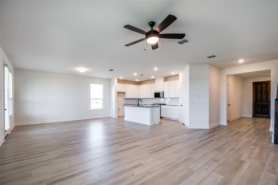 Unfurnished living room with a ceiling fan, light wood-style flooring, and recessed lighting Unfurnished living room with a ceiling fan, light wood-style flooring, and recessed lighting