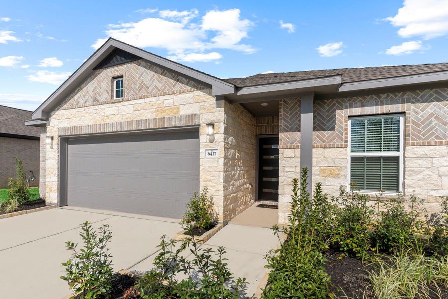 Step closer and admire the detailed brick and stone craftsmanship on this beautiful Sabine home! The elegant textures, trim details, and covered front entryway create a warm and welcoming first impression. Lush landscaping and a full sprinkler system add to the home’s curb appeal—truly a perfect blend of comfort and style.