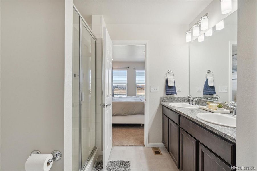 Looking from closet through bathroom to primary bedroom