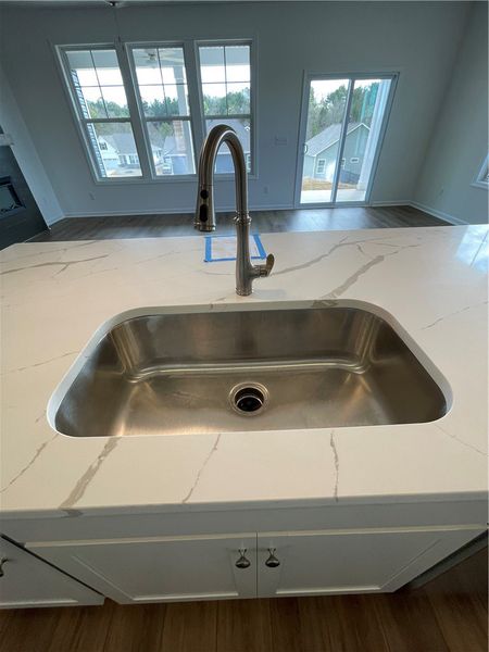 This bright kitchen features a large sink, elegant