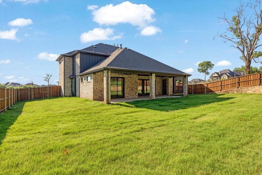 Rear view of house with a patio area and a lawn