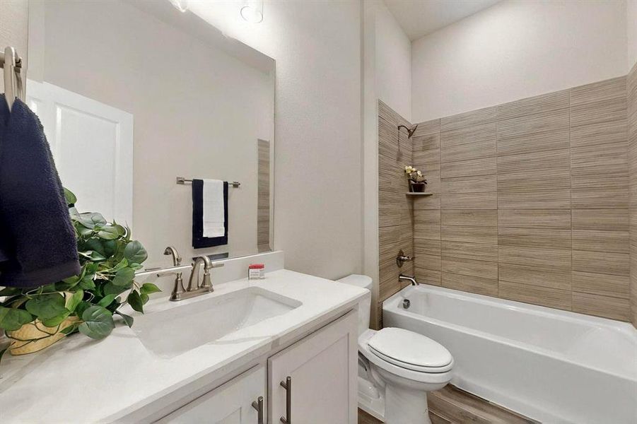Full bathroom with toilet, shower / washtub combination, wood finished floors, and vanity