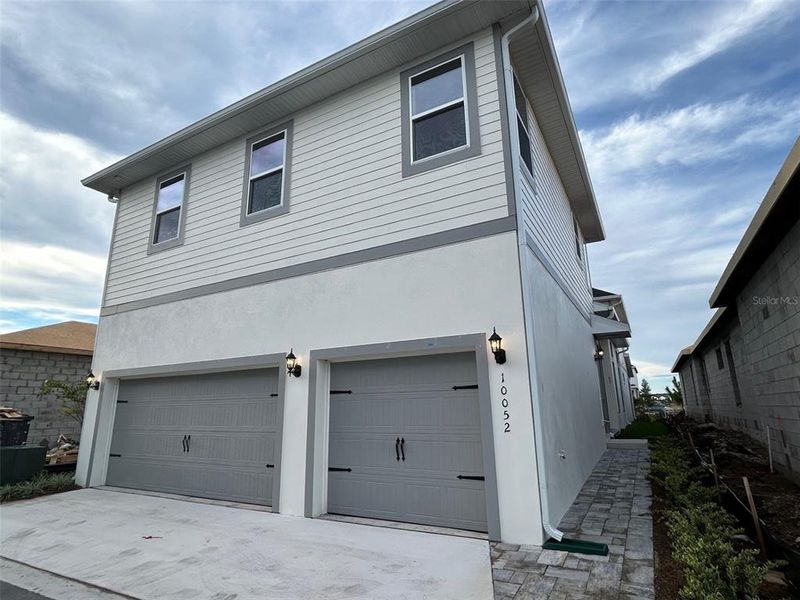 Front exterior of a new home in Laureate Park, Orlando, FL, highlighting curb appeal (Image 2). Front exterior of a new home in Laureate Park, Orlando, FL, highlighting curb appeal (Image 2).