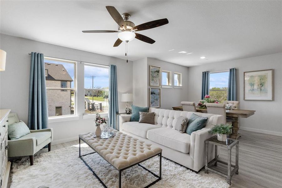 Living room featuring ceiling fan and light hardwood / wood-style floors