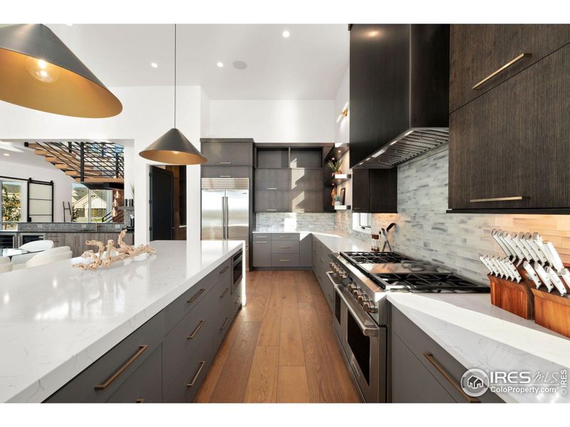 Expansive Countertops, Designer Lighting and Custom Built Range Hood