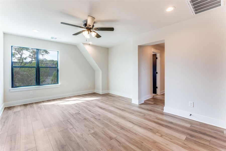 Additional living space with ceiling fan, light wood finished floors, and recessed lighting