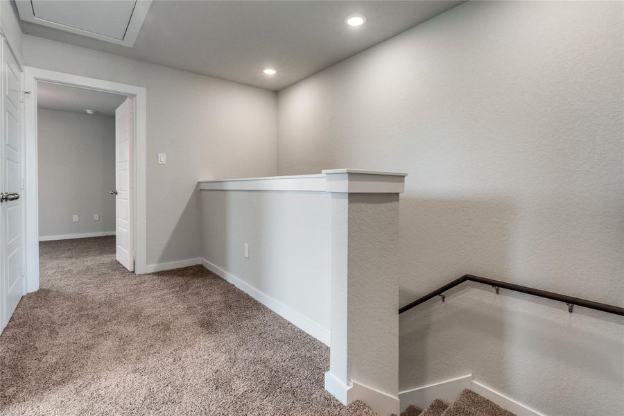 Hall with an upstairs landing, carpet, recessed lighting, and a textured wall Hall with an upstairs landing, carpet, recessed lighting, and a textured wall
