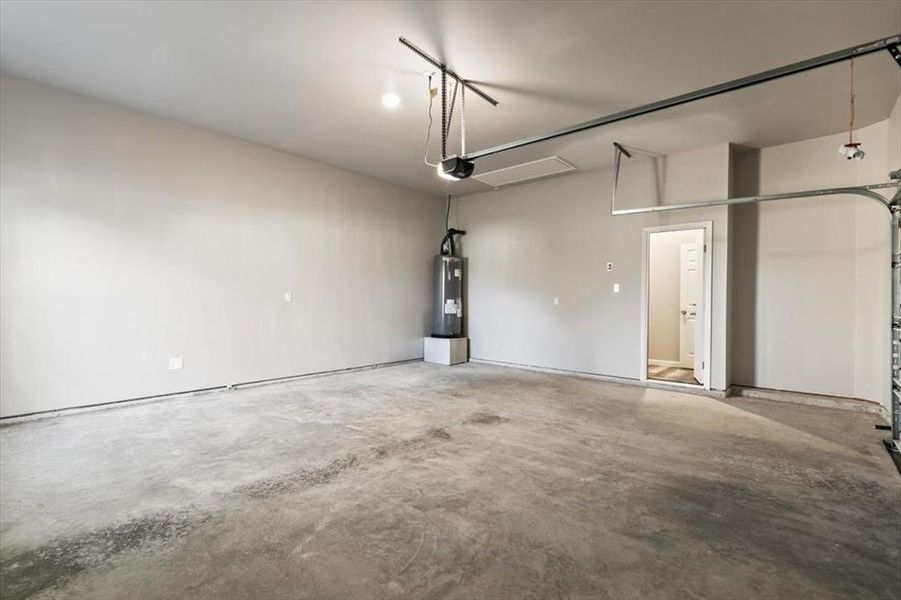 Garage featuring a garage door opener and water heater