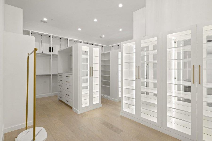 Custom cabinetry and ample shelving define this thoughtfully designed walk-in closet.