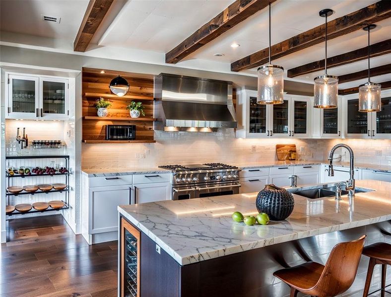 Bar with backsplash, dark wood finished floors, double oven range, wall chimney exhaust hood, and a sink