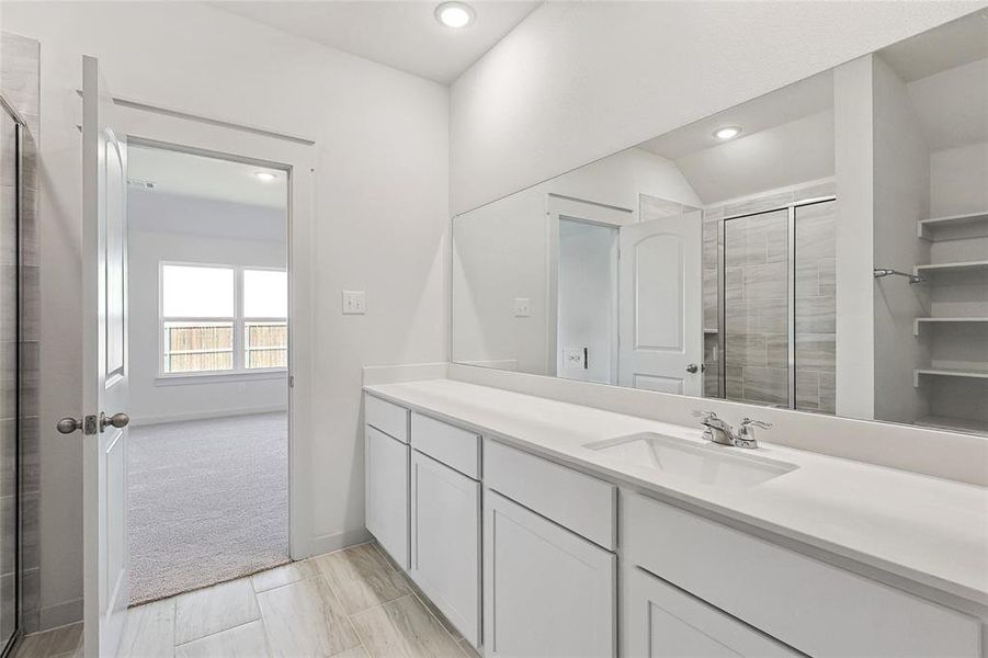 Bathroom featuring vanity, lofted ceiling, and an enclosed shower