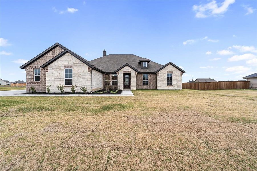 French country inspired facade with stone siding, a chimney, and a shingled roof
