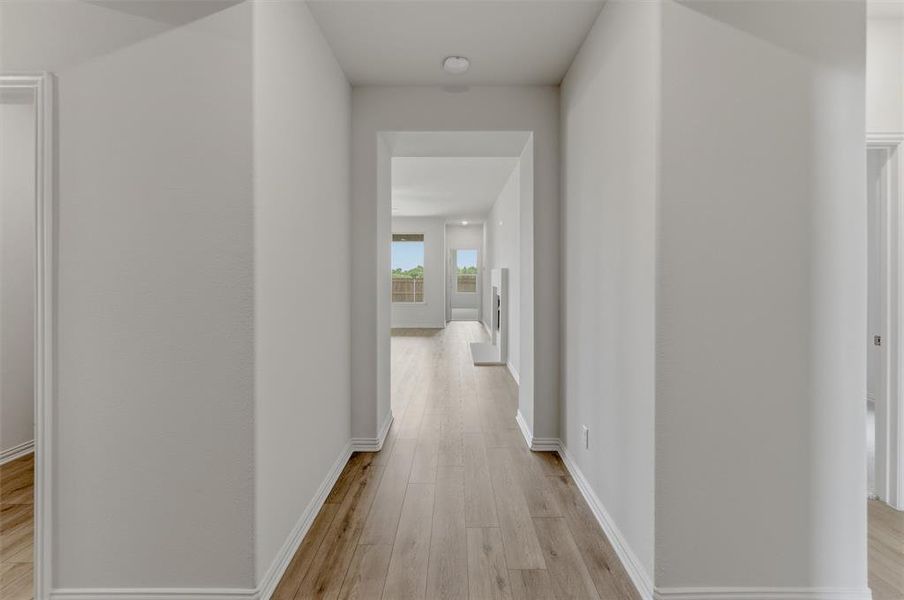 Entry hall featuring wood-finish flooring, white baseboards, and neutral wall paint