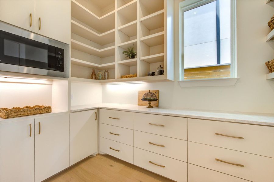 A spacious scullery pantry tucked just beyond the main kitchen offers additional storage, appliance space, prep counters, and organization, ensuring the primary kitchen remains beautifully uncluttered. Together, these thoughtfully curated spaces deliver a luxury culinary experience where elevated design meets everyday practicality.