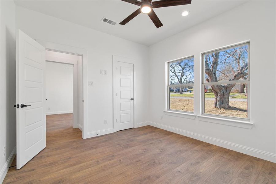 Unfurnished bedroom with ceiling fan and wood-type flooring