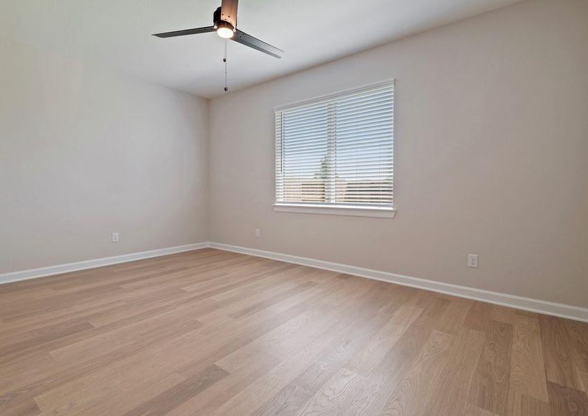 Master bedroom with a large window and ceiling fan light fixture Master bedroom with a large window and ceiling fan light fixture