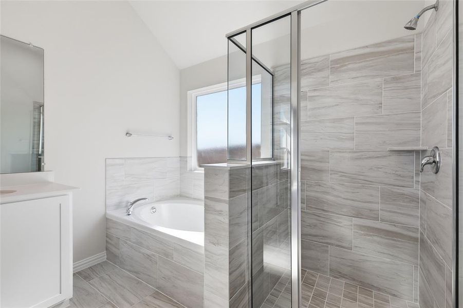 Bathroom featuring a glass-enclosed shower, a built-in tub with chrome fixtures, and a vanity with a white cabinet and countertop