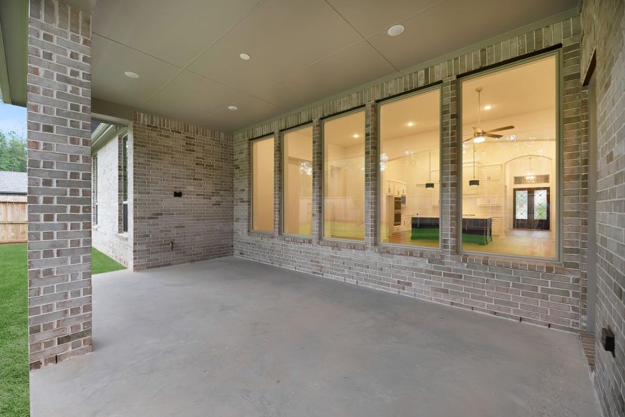 View of the covered back patio showing inside into the family room and kitchen. View of the covered back patio showing inside into the family room and kitchen.