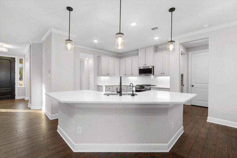 Kitchen featuring a sink, stainless steel appliances, baseboards, light countertops, and backsplash Kitchen featuring a sink, stainless steel appliances, baseboards, light countertops, and backsplash