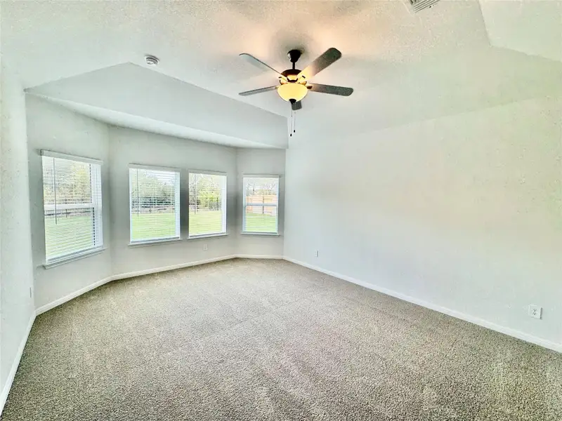 Empty room featuring a textured ceiling, carpet, and a ceiling fan Empty room featuring a textured ceiling, carpet, and a ceiling fan