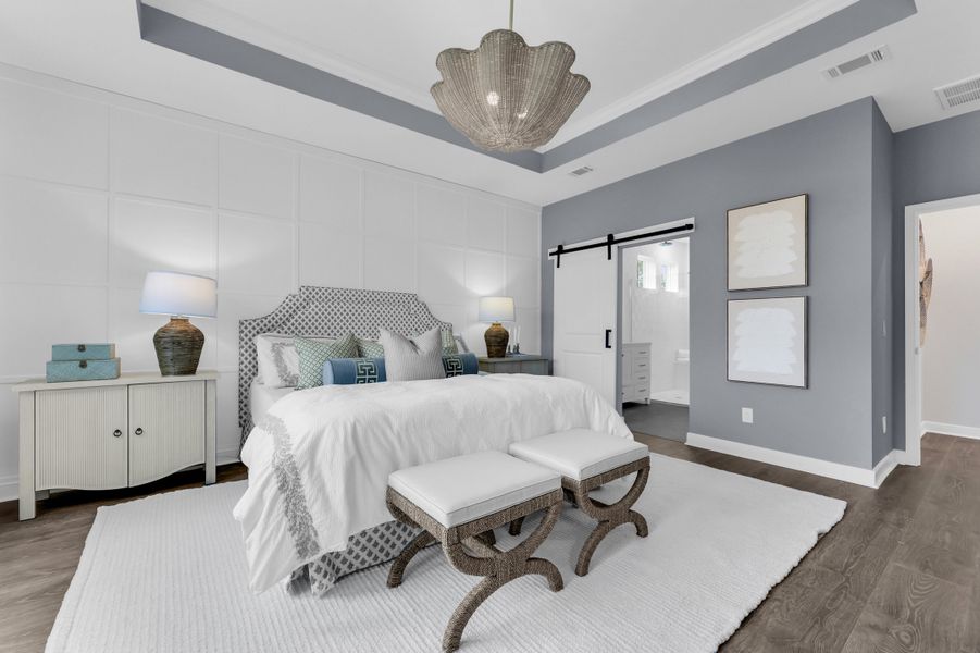 Primary suite with barn door and decorative feature wall