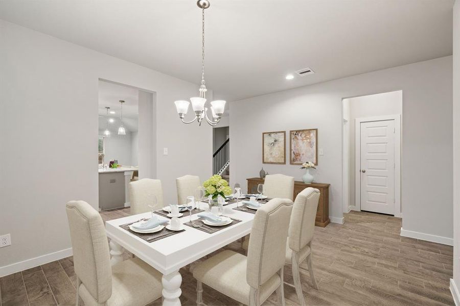 Create lasting memories with your family and friends at the dining table! This expansive dining room showcases sophisticated flooring, custom paint, and seamlessly connects to the family room and kitchen, providing an open and inviting atmosphere. Representation. Actual color and selections can vary.