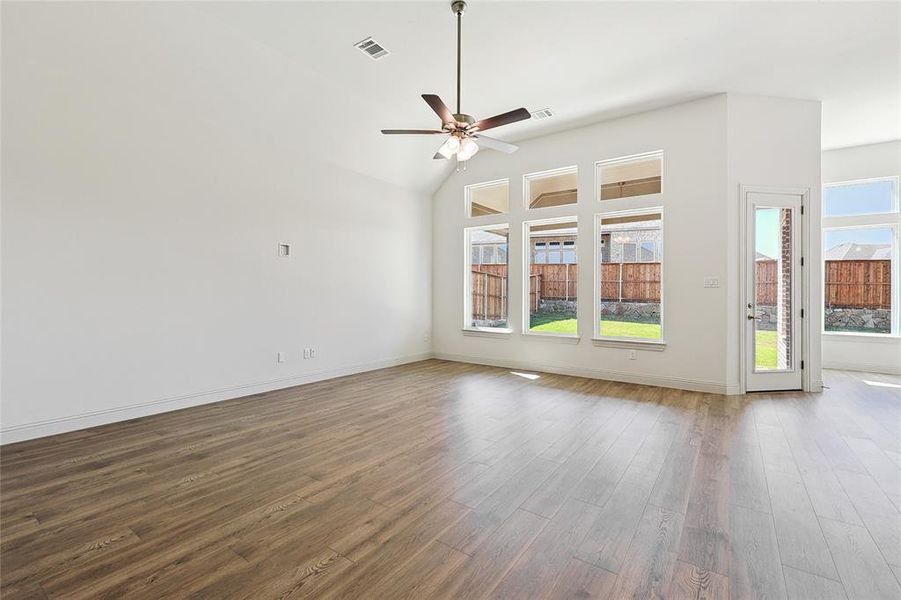 Spare room with ceiling fan, dark wood-style floors, and lofted ceiling