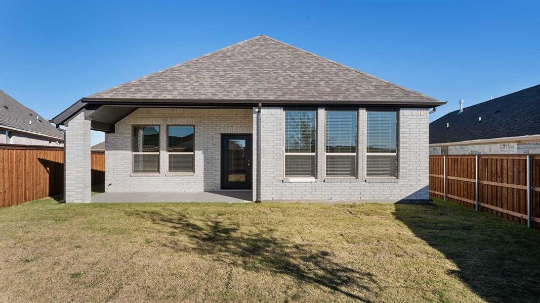 Back of house featuring a lawn and a patio