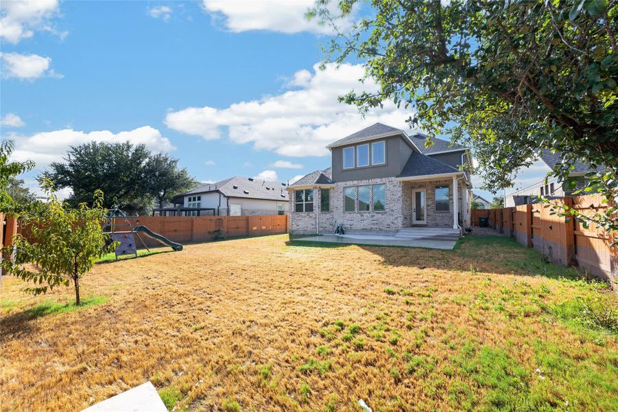 A spacious backyard is enclosed by a privacy fence behind the two-story home. A spacious backyard is enclosed by a privacy fence behind the two-story home.