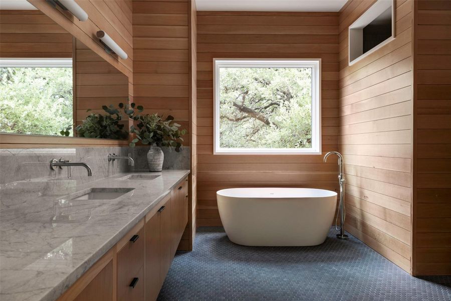 Bathroom featuring wood walls, a freestanding tub, and double vanity