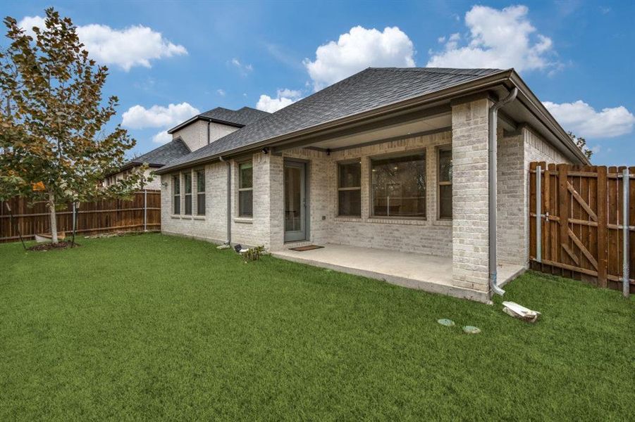 Rear view of house with a patio, a fenced backyard, brick siding, and a shingled roof Rear view of house with a patio, a fenced backyard, brick siding, and a shingled roof
