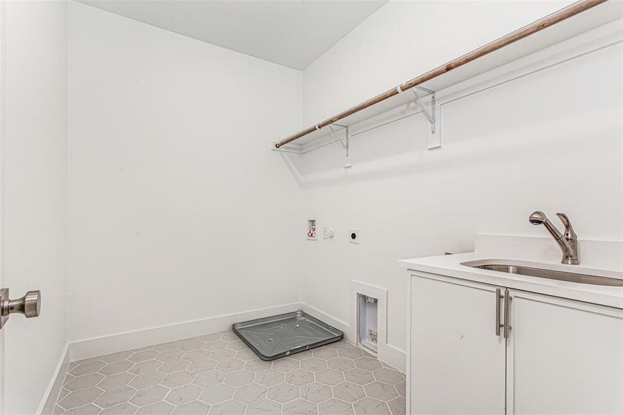Laundry room with electric dryer hookup, hookup for a washing machine, baseboards, light tile patterned floors, and cabinet space