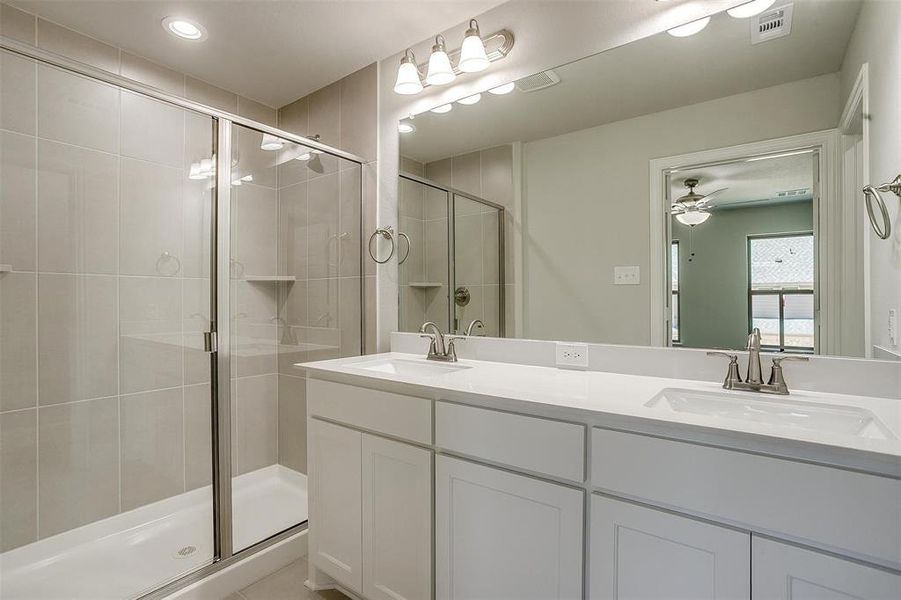 Bathroom featuring a shower stall, double vanity, ceiling fan, and recessed lighting Bathroom featuring a shower stall, double vanity, ceiling fan, and recessed lighting